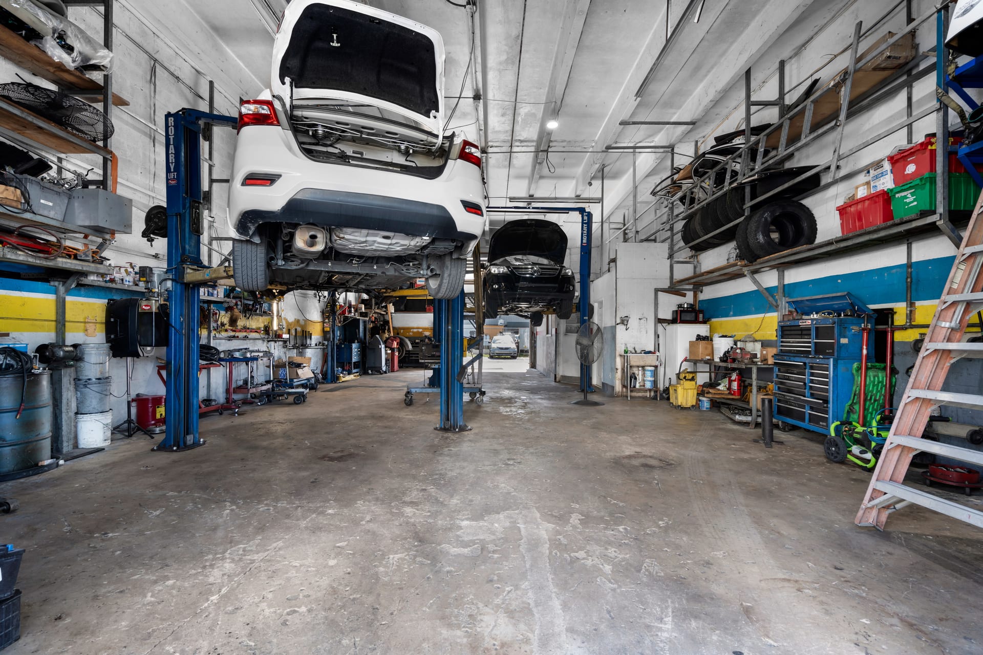 Looking down the service bays at Wires Auto Repair, Miami, with two cars raised on lifts