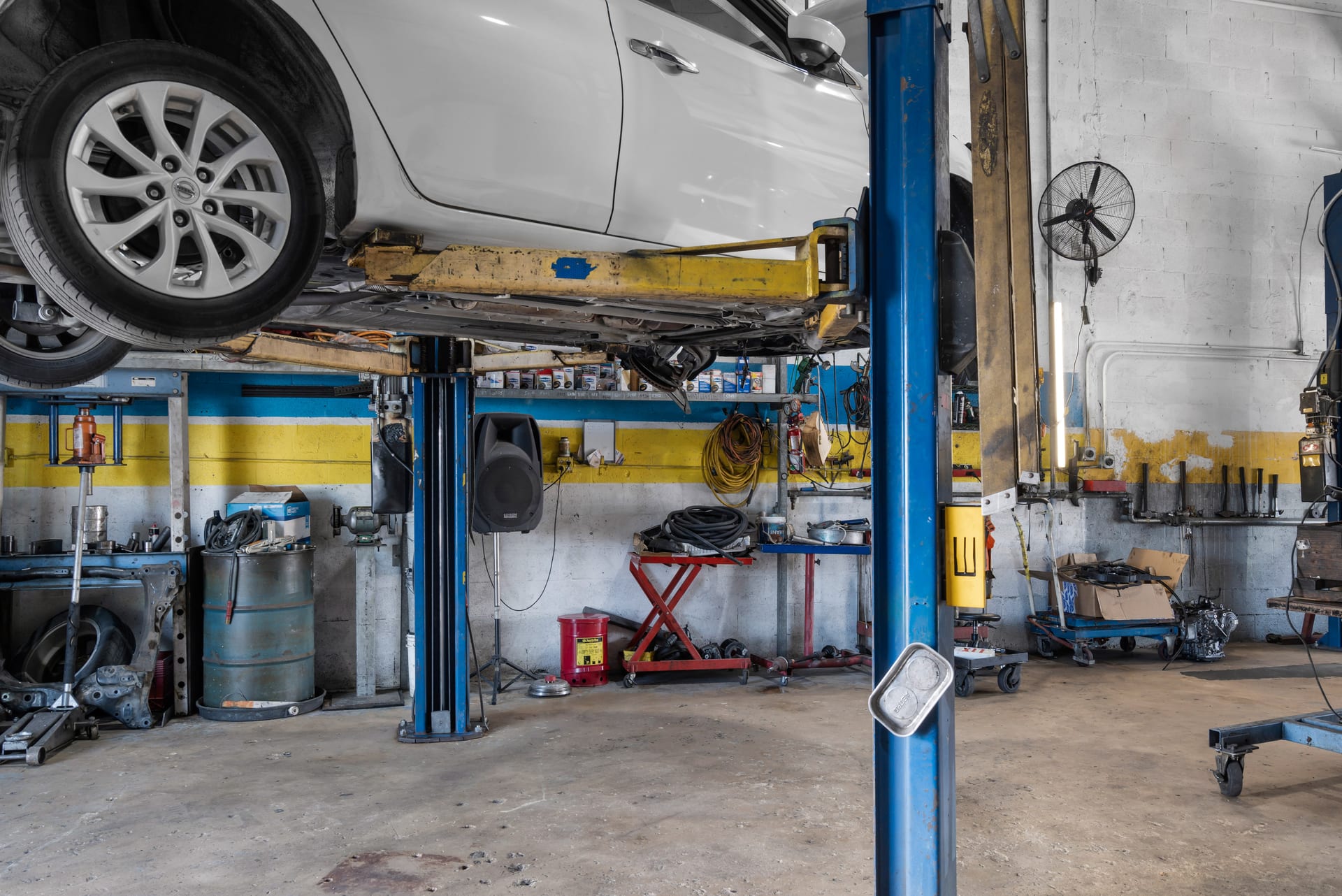 Car raised on a lift with its wheels off the ground at Wires Auto Repair, Miami